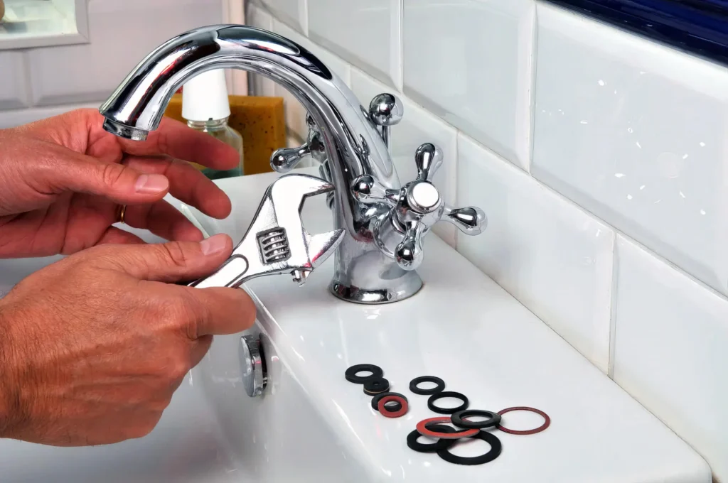 Plumber performing maintenance on a bathroom faucet in Carlisle