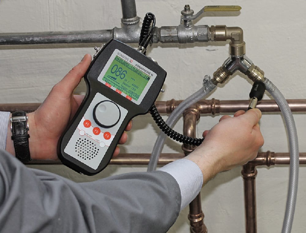 Plumber testing pipes with electronic leak detection equipment in Carlisle