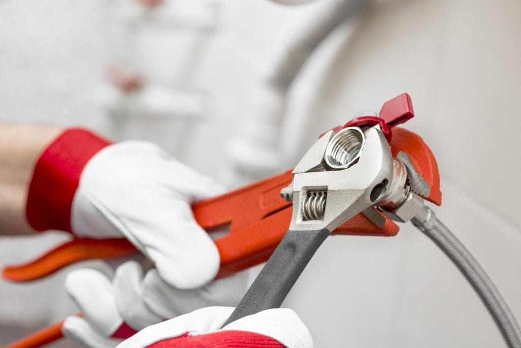 Plumber holding pipe wrenches for an emergency repair in Carlisle