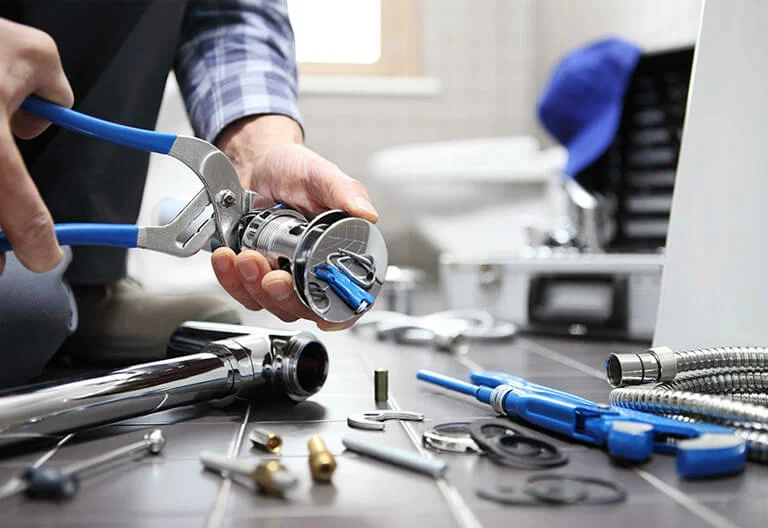Technician repairing a plumbing fixture with professional tools in Carlisle