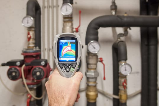 Plumber using a thermal imaging camera to inspect pipes in Carlisle