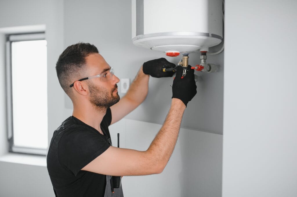 Technician performing water heater maintenance in Carlisle