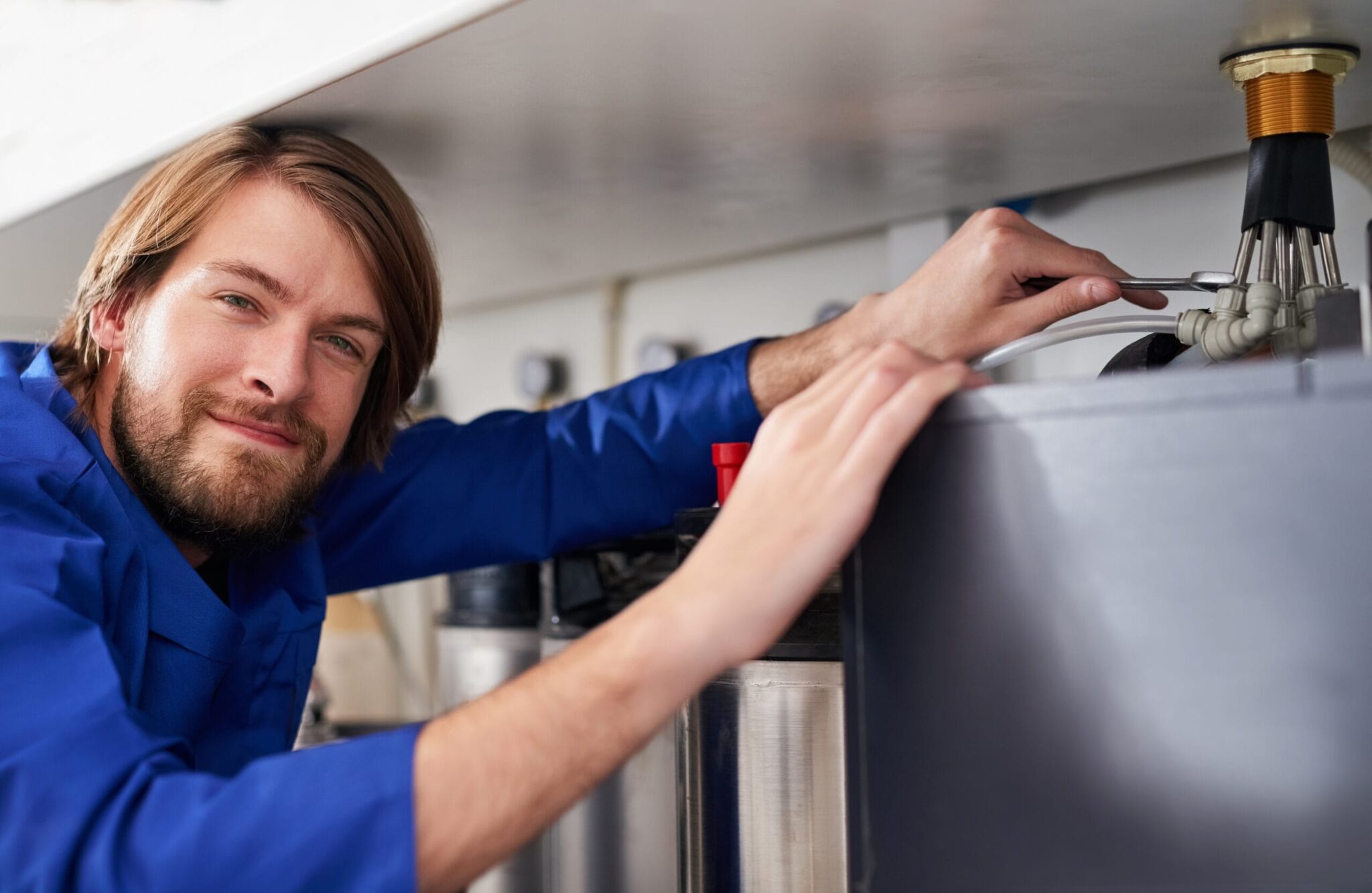Technician servicing a residential water heater tank in Carlisle