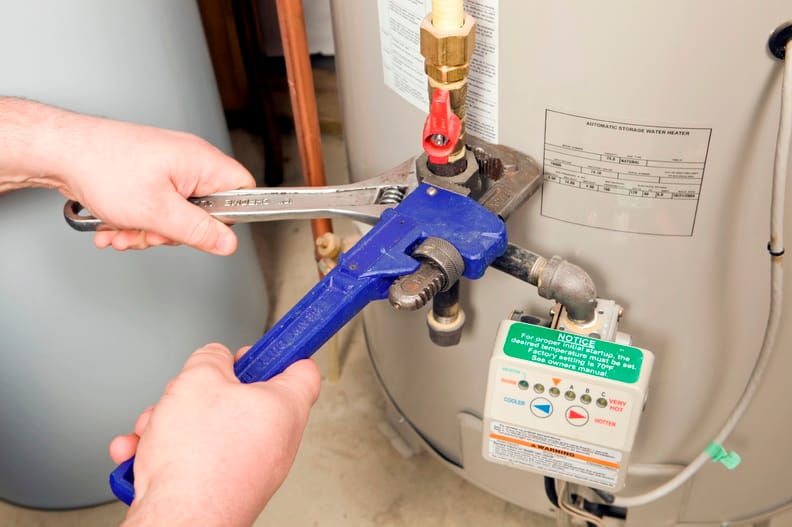 Plumber repairing a water heater valve in Carlisle